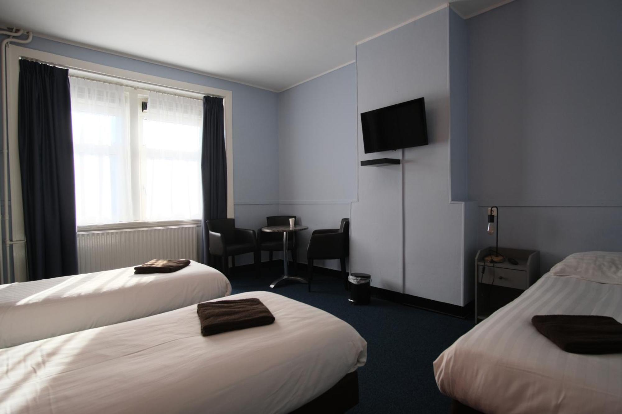 Deze driepersoonskamer heeft een gedeelde badkamer.