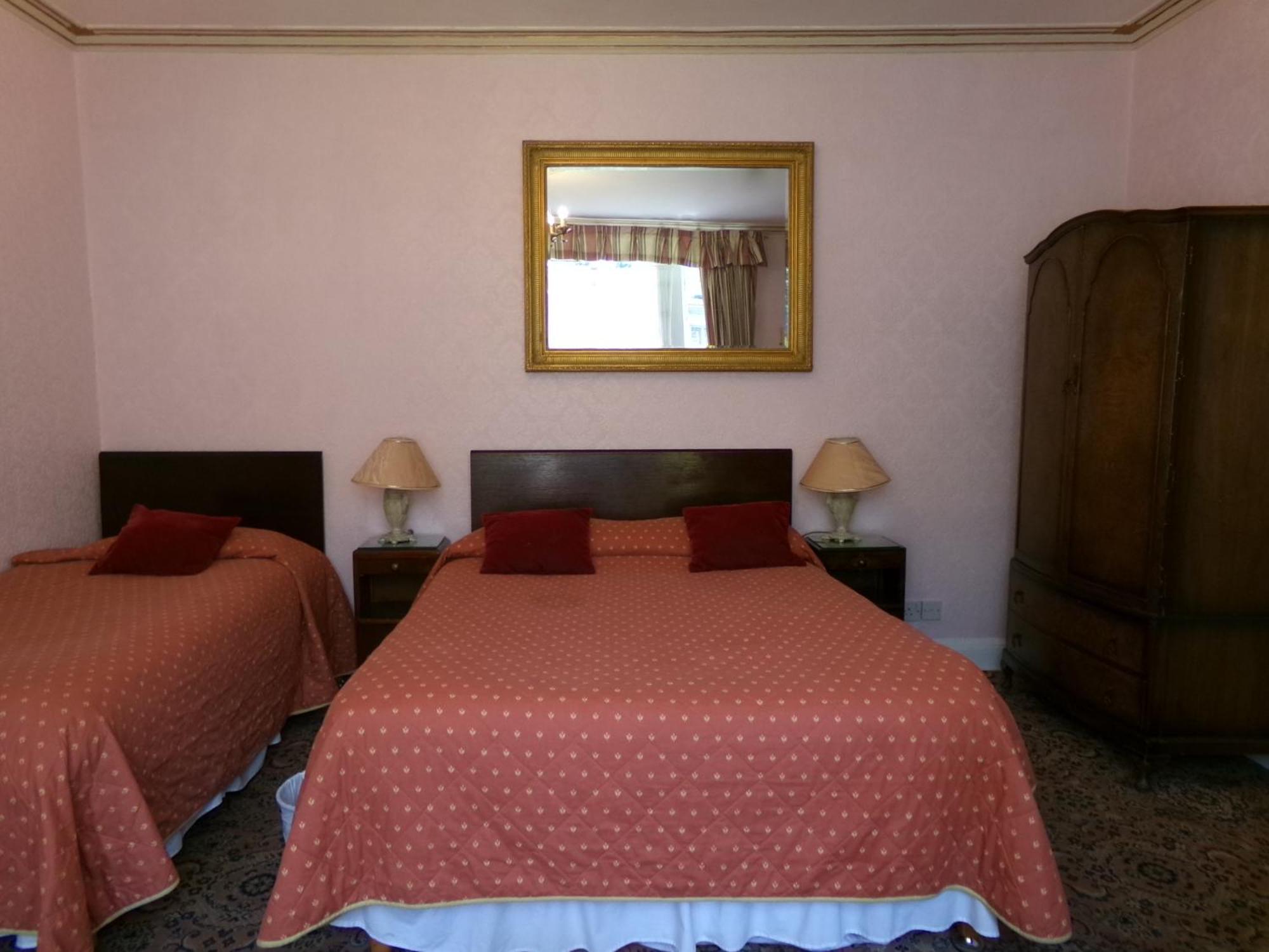 Deze driepersoonskamer heeft een gedeelde badkamer.
